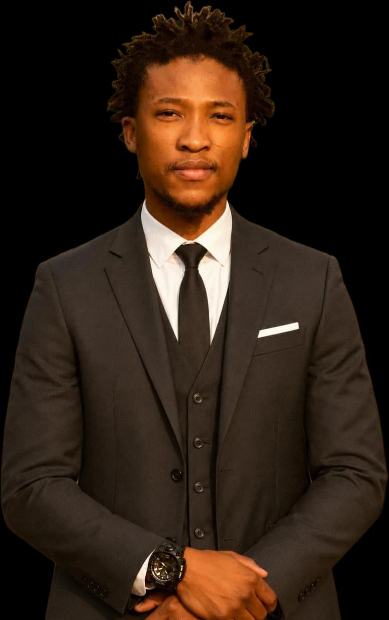 Tumo Mogame, in a dark three-piece suit and tie, hands clasped