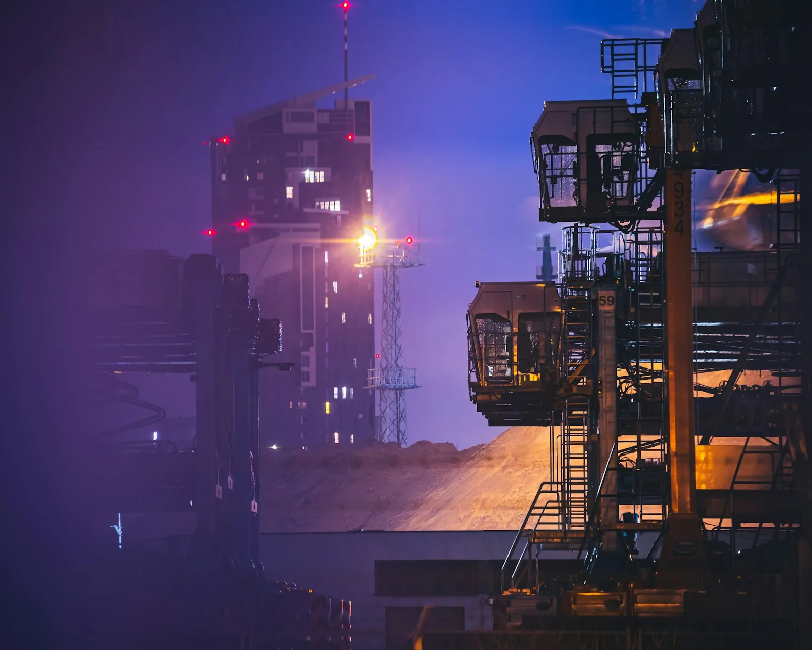 Port cranes standing in mist at dusk